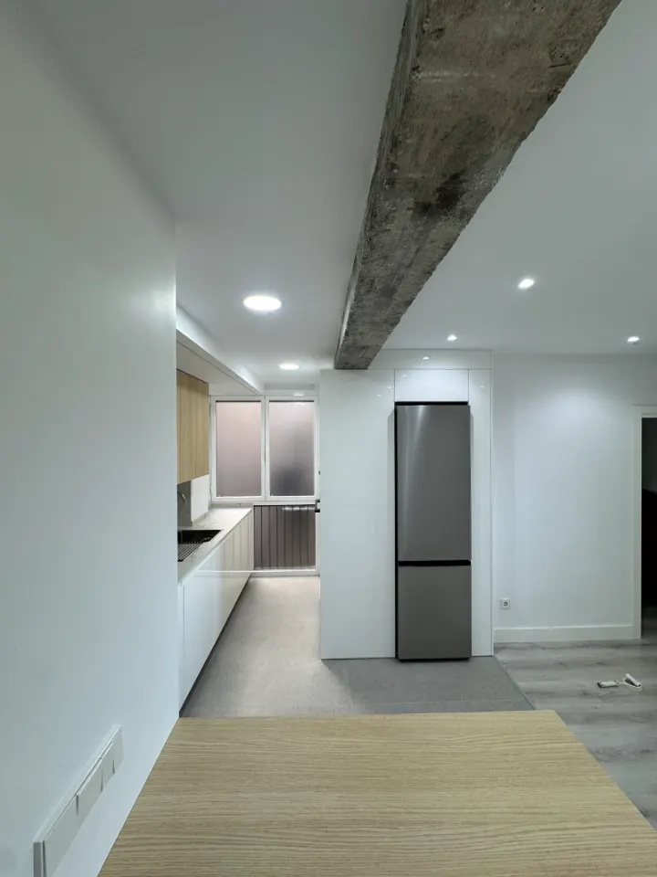 Vivienda reformada con viga vista y cocina abierta